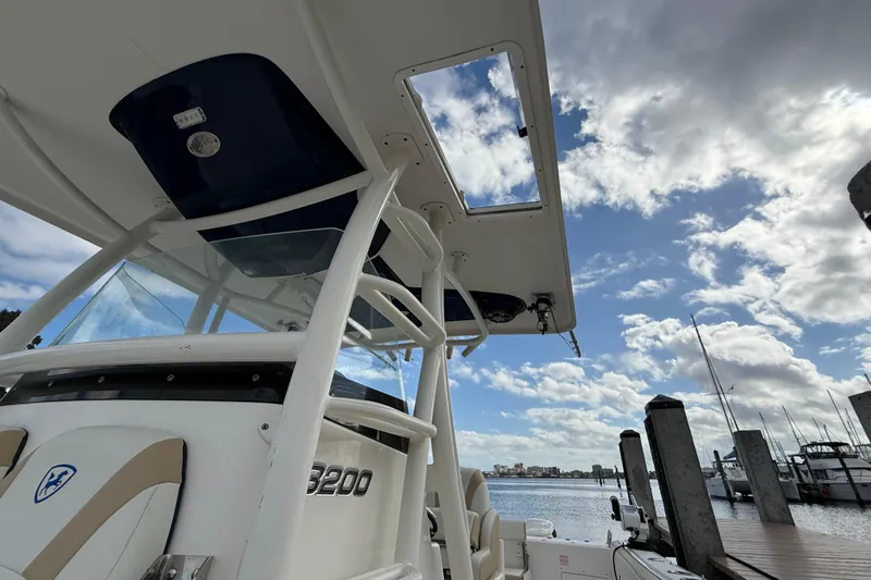 Big Blue Yacht Photos Pics 2017 Century 3200 Center Console boat docked under a partly cloudy sky.