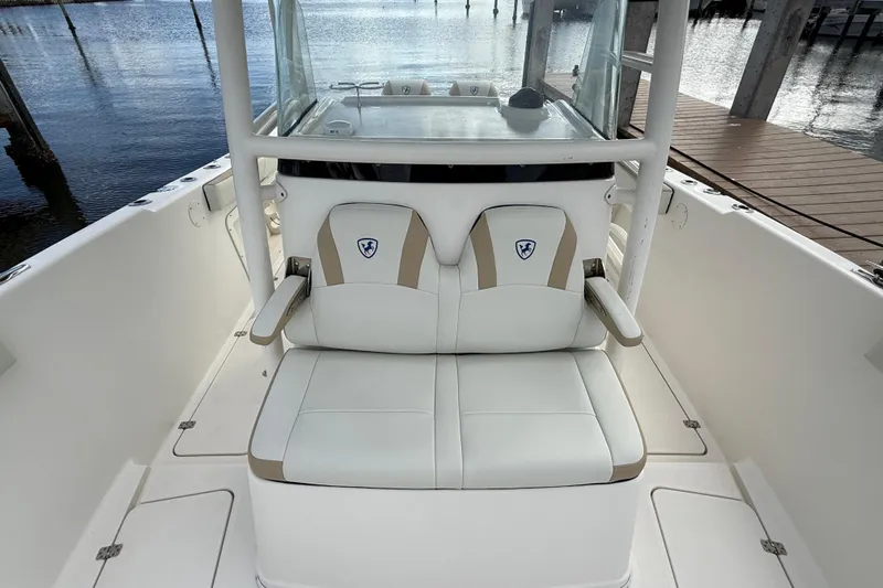 Big Blue Yacht Photos Pics 2017 Century 3200 Center Console boat with white seating, docked by the water.