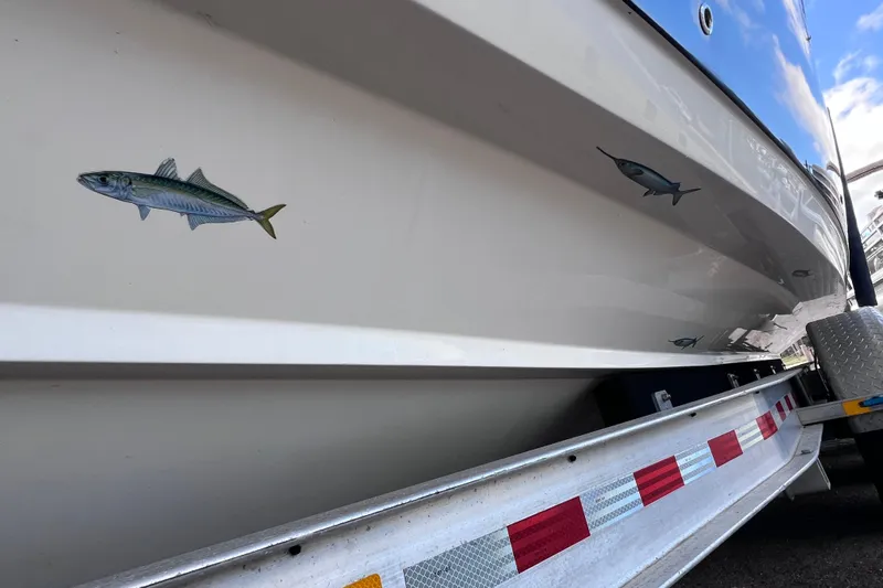 Big Blue Yacht Photos Pics 2017 Century 3200 Center Console boat with fish decals on the hull, on a trailer.