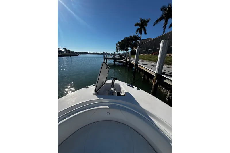  Yacht Photos Pics Bow view of 2015 Edgewater 320CC boat docked by palm trees.