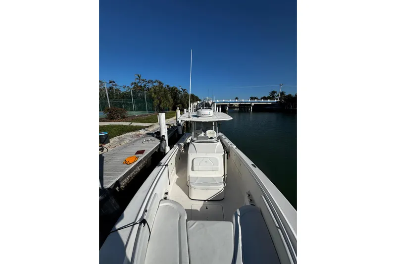 Yacht Photos Pics 2015 Edgewater 320CC boat docked by a calm waterfront under clear blue skies.