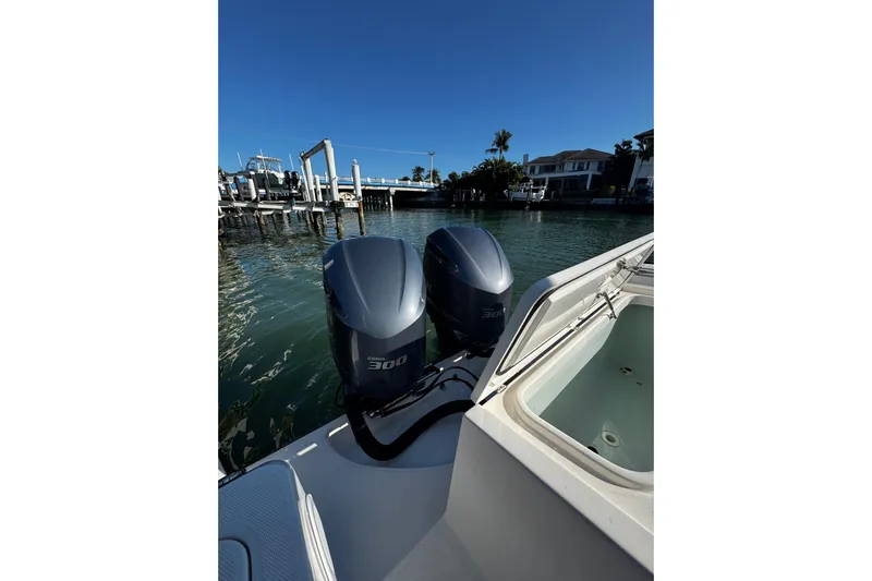  Yacht Photos Pics 2015 Edgewater 320CC boat with dual 300 horsepower engines docked by waterfront homes.