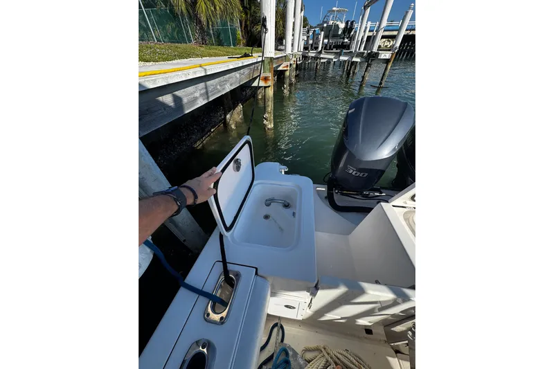  Yacht Photos Pics 2015 Edgewater 320CC boat with open hatch and powerful outboard engine at dock.