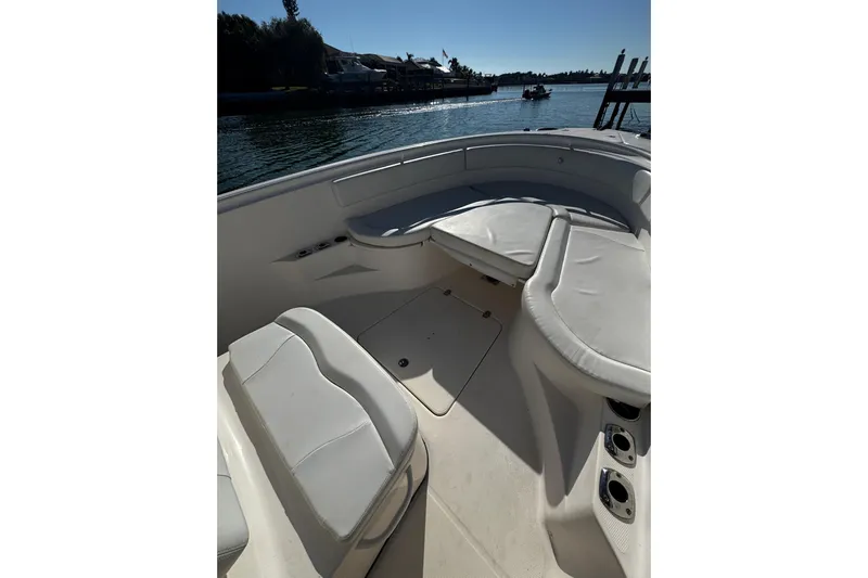  Yacht Photos Pics 2015 Edgewater 320CC boat interior with cushioned seating, docked by calm waters.