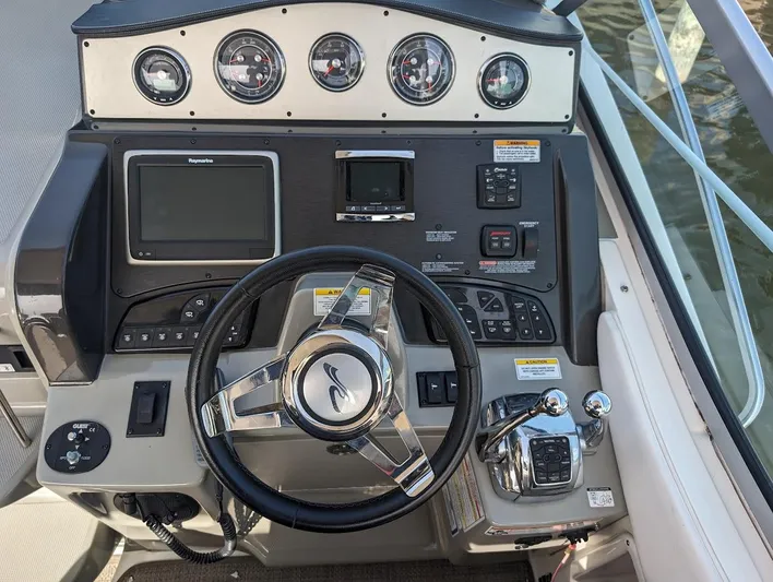 So Lucky Yacht Photos Pics 2015 Sea Ray 330 Sundancer helm with steering wheel, gauges, and navigation controls.
