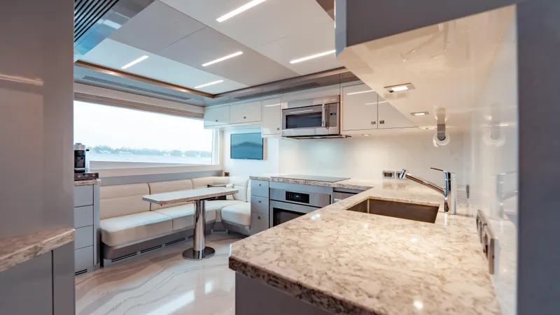 Pinch Me Yacht Photos Pics Luxurious kitchen interior of 2021 Ocean Alexander 28R yacht with modern appliances and seating area.
