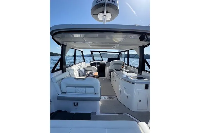  Yacht Photos Pics 2021 Regal 36 Grande Coupe interior with seating and navigation equipment on a sunny day.