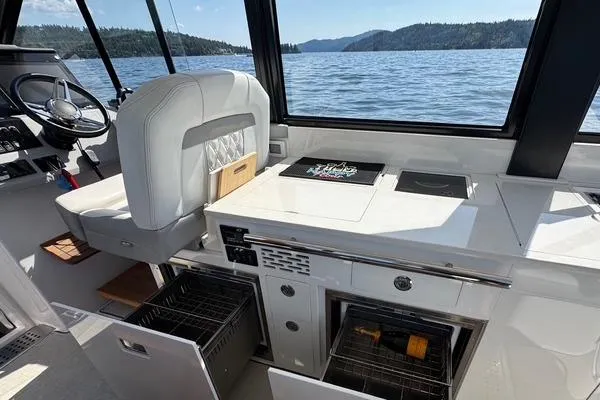  Yacht Photos Pics 2021 Regal 36 Grande Coupe interior with helm, kitchen, and scenic lake view.