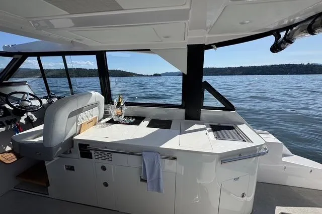  Yacht Photos Pics 2021 Regal 36 Grande Coupe interior with lake view, featuring modern helm and seating area.