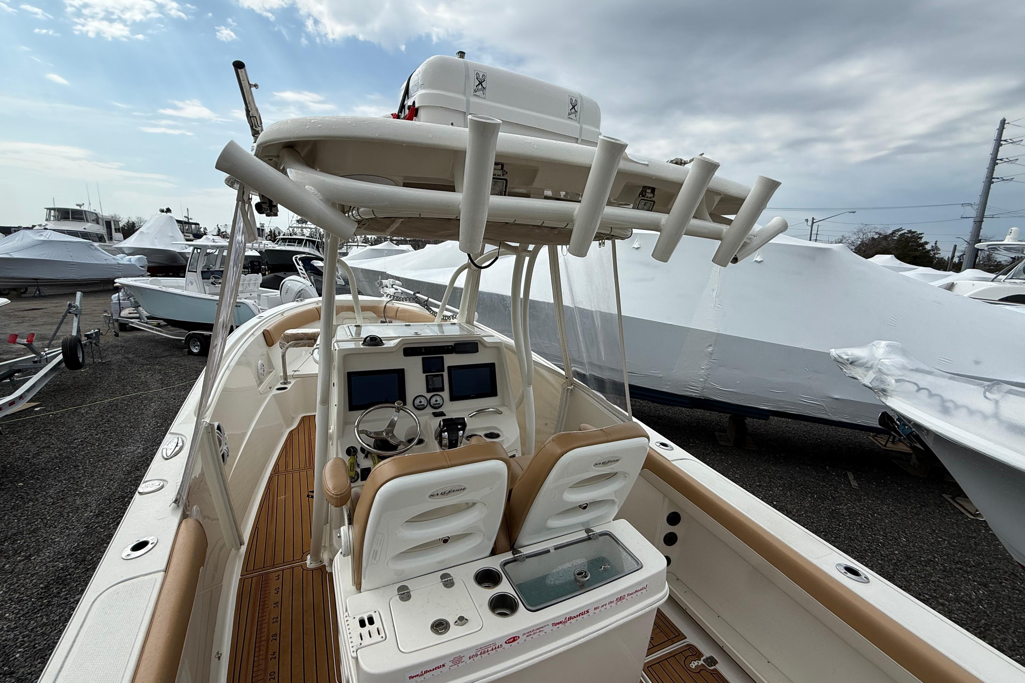 2015 Sailfish 2860 CC boat with dual consoles and rod holders, docked under cloudy skies.