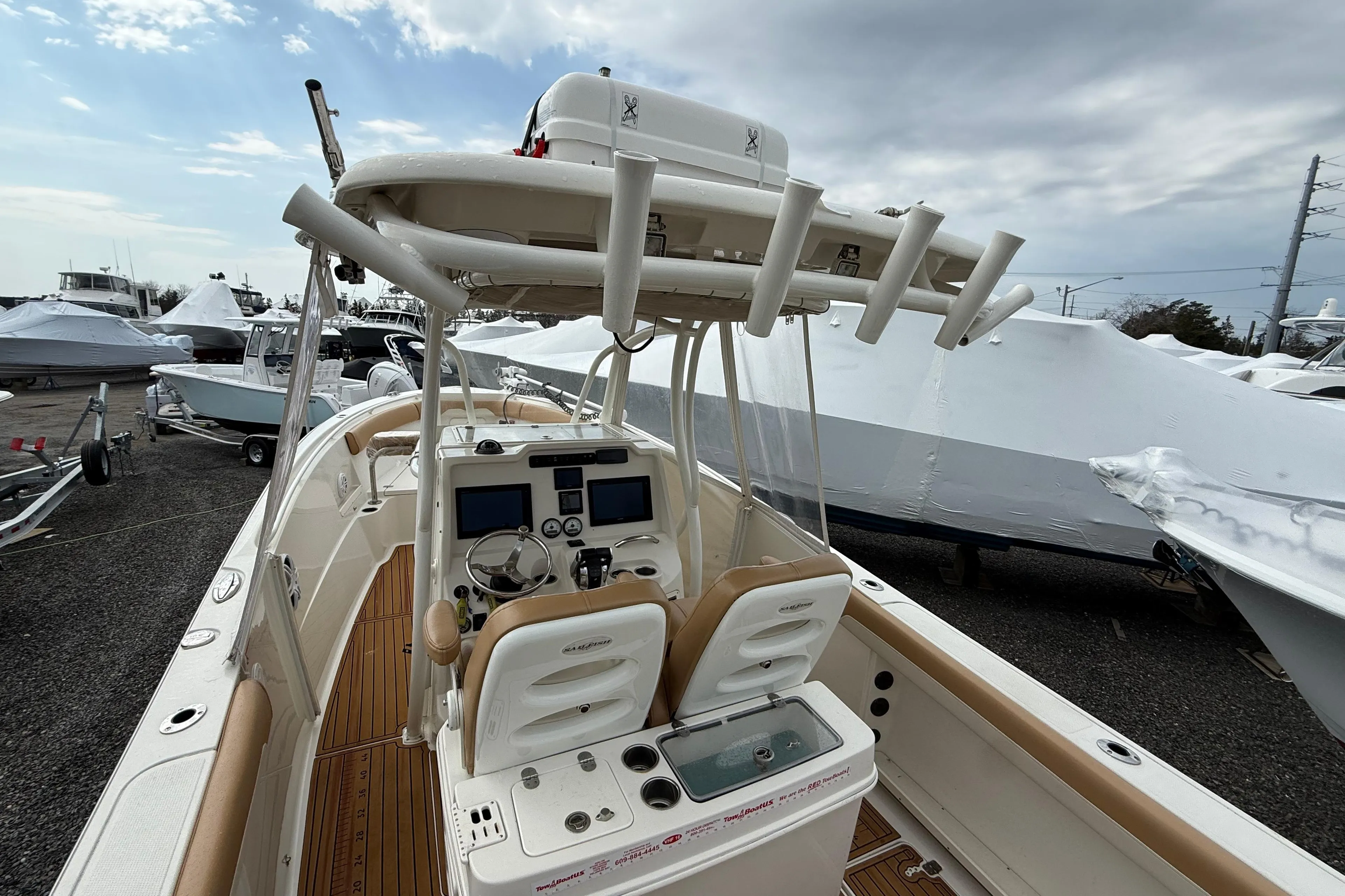 2015 Sailfish 2860 CC boat with dual consoles and rod holders, docked under cloudy skies.