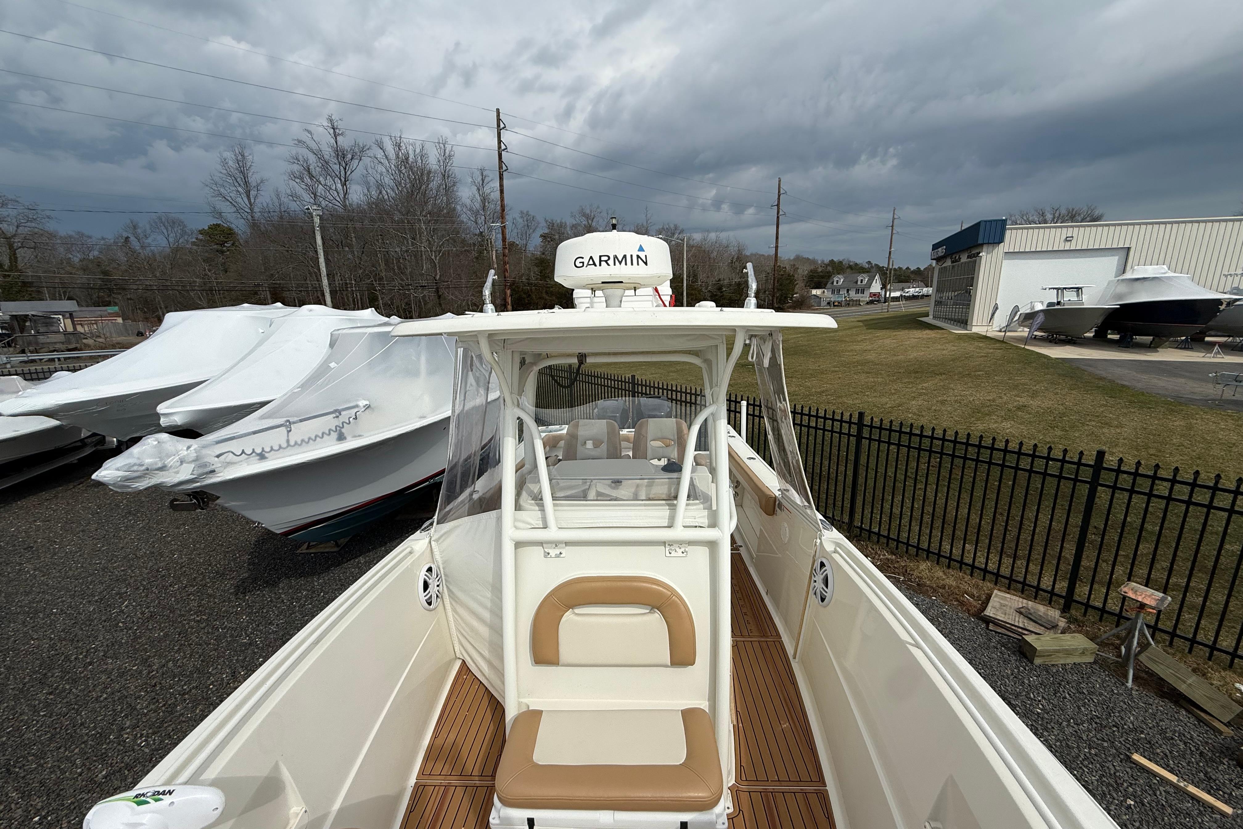 2015 Sailfish 2860 CC boat with Garmin equipment, docked outdoors under cloudy skies.