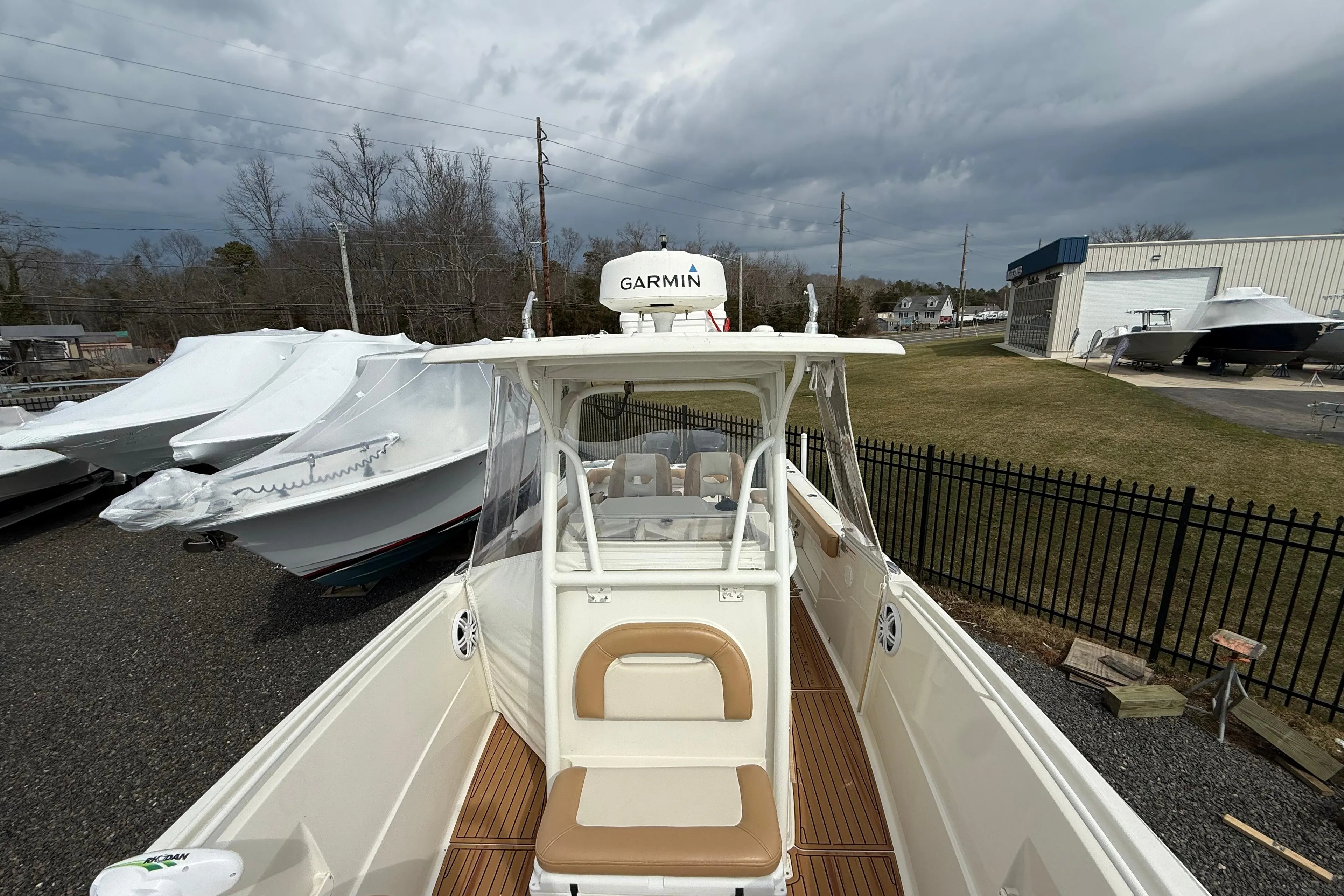 2015 Sailfish 2860 CC boat with Garmin equipment, docked outdoors under cloudy skies.