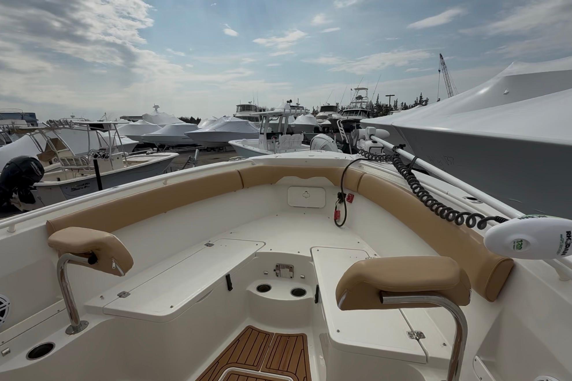 2015 Sailfish 2860 CC boat interior with seating and deck, docked among other boats.