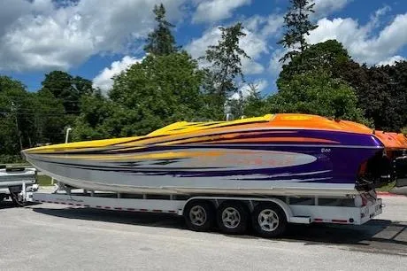  Yacht Photos Pics 2008 Nor-Tech 3600 Supercat powerboat on trailer, vibrant yellow and purple design, parked outdoors.