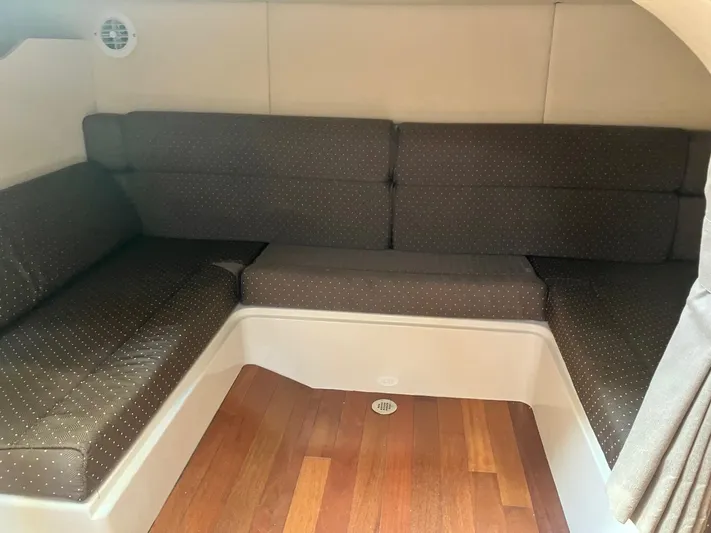  Yacht Photos Pics 2009 Boston Whaler 345 Conquest cabin interior with cushioned seating and wooden flooring.