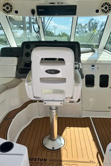  Yacht Photos Pics 2009 Boston Whaler 345 Conquest helm with captain's chair and wood-patterned flooring.