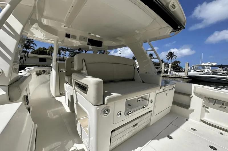  Yacht Photos Pics 2019 Boston Whaler 350 Realm interior with seating, sleek design, and marina backdrop.