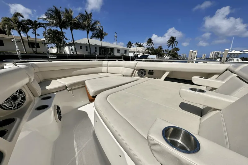  Yacht Photos Pics 2019 Boston Whaler 350 Realm boat interior with beige seating and cup holders, under a clear blue sky.