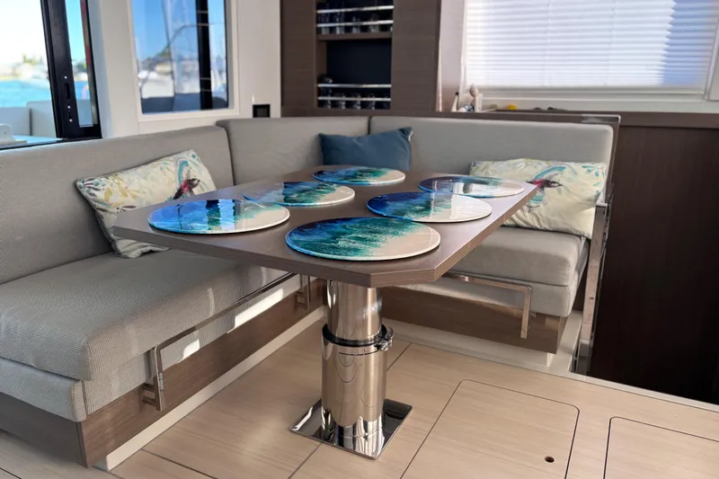  Yacht Photos Pics Modern interior of 2022 Leopard 42 yacht with stylish dining area and decorative cushions.