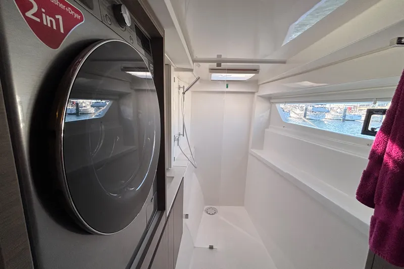  Yacht Photos Pics Laundry area with washer-dryer in 2022 Leopard 42 yacht, featuring a window view.