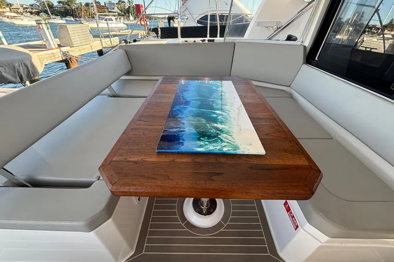  Yacht Photos Pics Leopard 42 yacht interior with elegant wooden table and ocean-themed artwork, 2022 model.