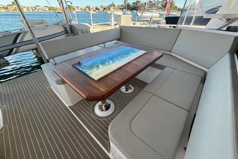  Yacht Photos Pics Luxurious seating area on 2022 Leopard 42 yacht with elegant wooden table.