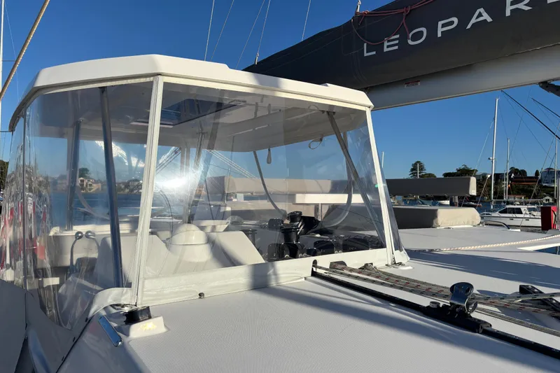  Yacht Photos Pics 2022 Leopard 42 catamaran with clear cockpit enclosure, docked in a marina.
