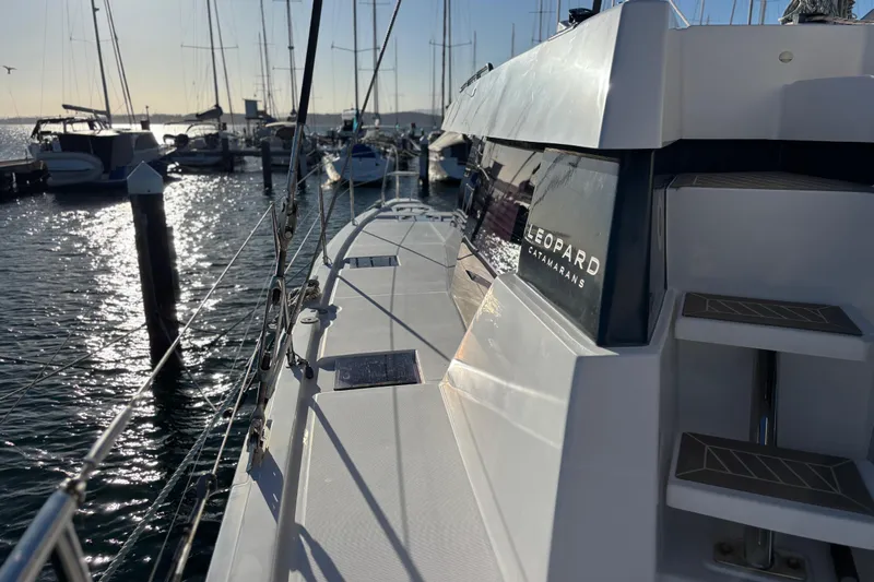  Yacht Photos Pics 2022 Leopard 42 catamaran docked at marina, sunlit water in background.