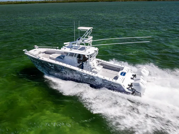  Yacht Photos Pics 2023 Freeman 37 VH boat cruising on vibrant green water, showcasing sleek design and powerful engines.