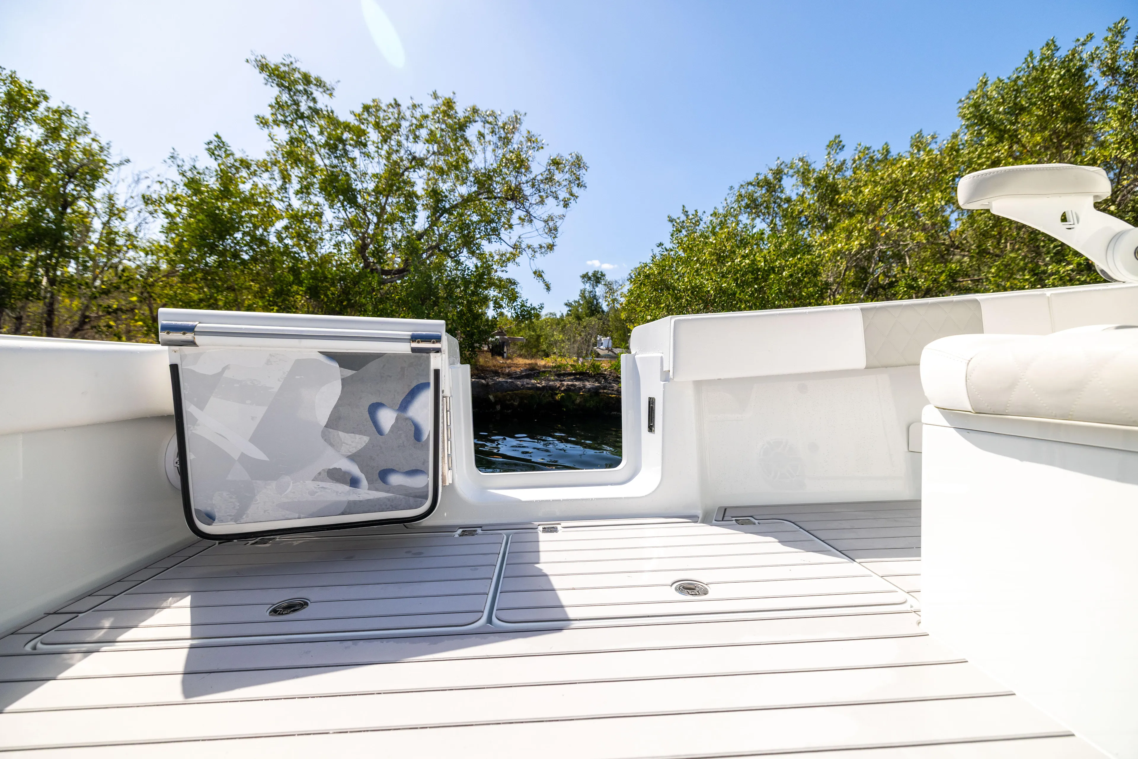  Yacht Photos Pics Freeman 37 VH 2023 boat deck with open door, surrounded by trees and water.