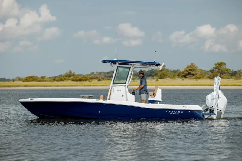  Yacht Photos Pics 2025 Caymas 26 HB boat on calm water with a person at the helm.