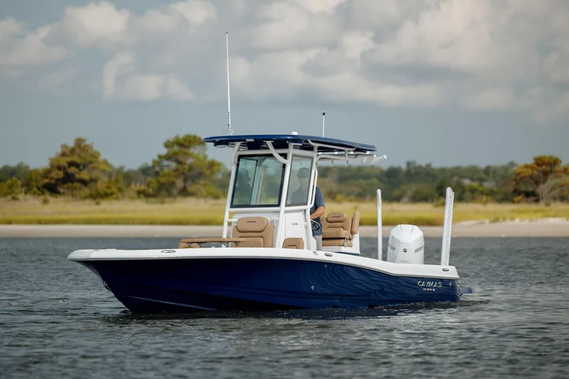  Yacht Photos Pics 2025 Caymas 26 HB boat on calm water with scenic background.