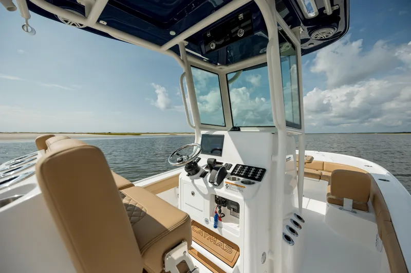  Yacht Photos Pics 2025 Caymas 26 HB boat interior with steering console, beige seating, and ocean view.