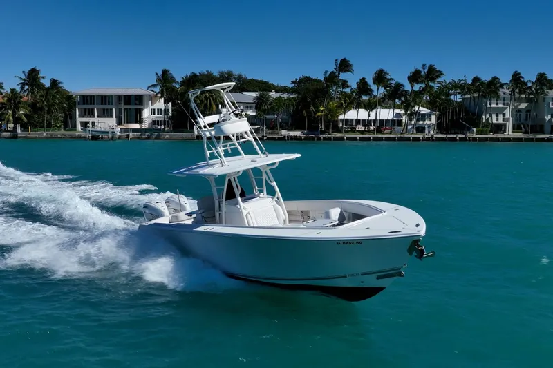  Yacht Photos Pics 2019 Jupiter 38 HFS boat cruising on turquoise water near palm-lined shore.