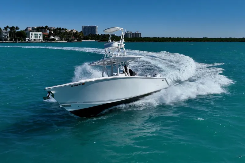  Yacht Photos Pics 2019 Jupiter 38 HFS boat cruising on turquoise waters near a coastal city.