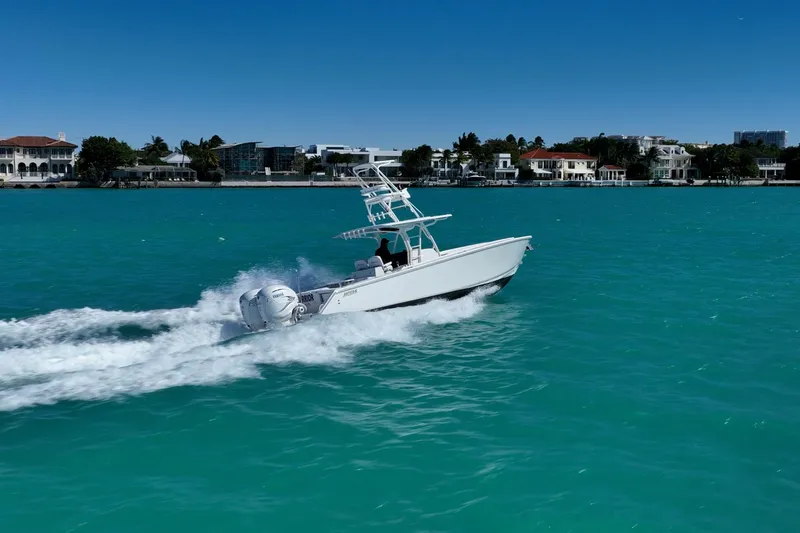  Yacht Photos Pics 2019 Jupiter 38 HFS boat cruising on turquoise water near luxury waterfront homes.
