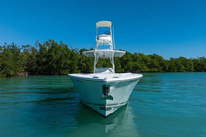  Yacht Photos Pics 2019 Jupiter 38 HFS boat on calm water, surrounded by lush greenery.