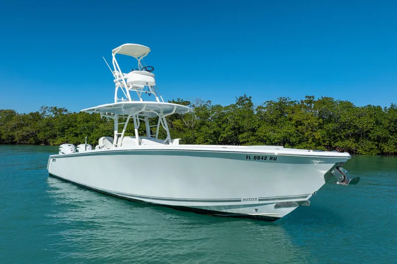  Yacht Photos Pics 2019 Jupiter 38 HFS boat on calm water with lush green background.
