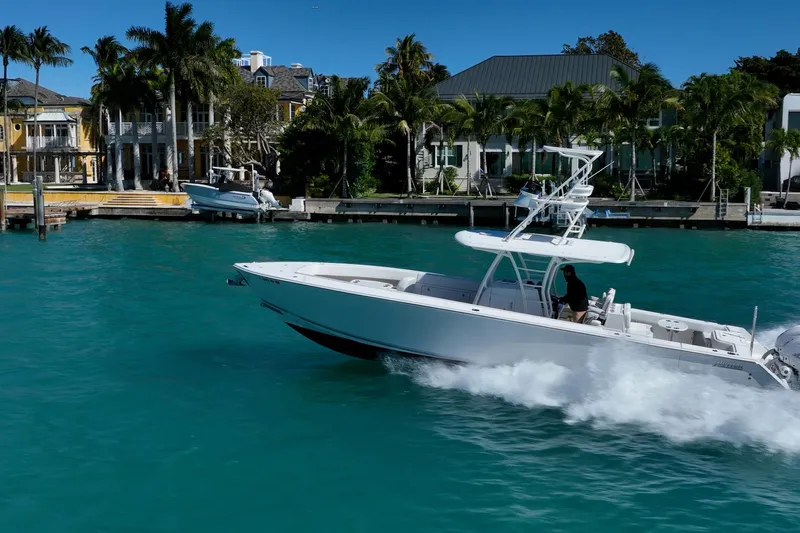  Yacht Photos Pics 2019 Jupiter 38 HFS boat cruising in turquoise waters near luxury waterfront homes.