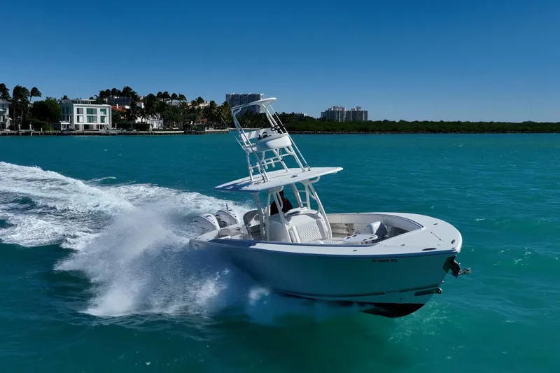  Yacht Photos Pics 2019 Jupiter 38 HFS boat cruising on turquoise water near a coastal city.