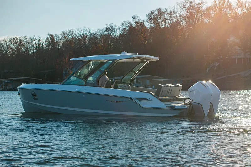  Yacht Photos Pics 2026 Monterey Elite 30 OB boat on a serene lake at sunset.