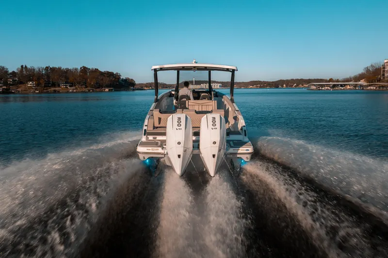  Yacht Photos Pics 2026 Monterey Elite 30 OB boat cruising on a serene lake under a clear blue sky.
