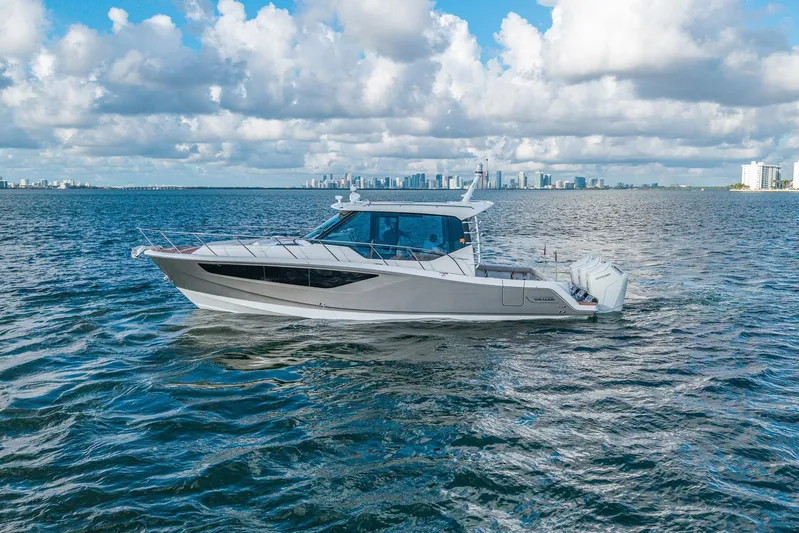  Yacht Photos Pics 2024 Boston Whaler 405 Conquest cruising on open water under a cloudy sky.