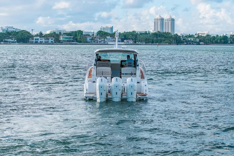  Yacht Photos Pics 2024 Boston Whaler 405 Conquest cruising on a scenic waterway with city skyline.