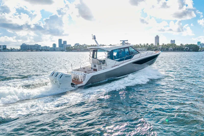  Yacht Photos Pics 2024 Boston Whaler 405 Conquest cruising on a sunny day near city skyline.