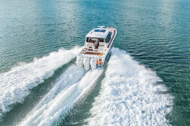  Yacht Photos Pics 2024 Boston Whaler 405 Conquest cruising on open water, rear view.