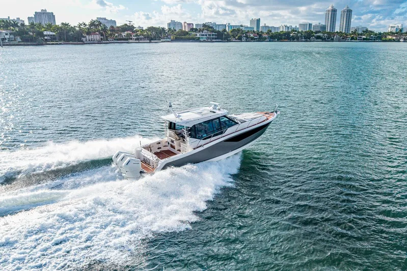  Yacht Photos Pics 2024 Boston Whaler 405 Conquest cruising on open water, city skyline in background.