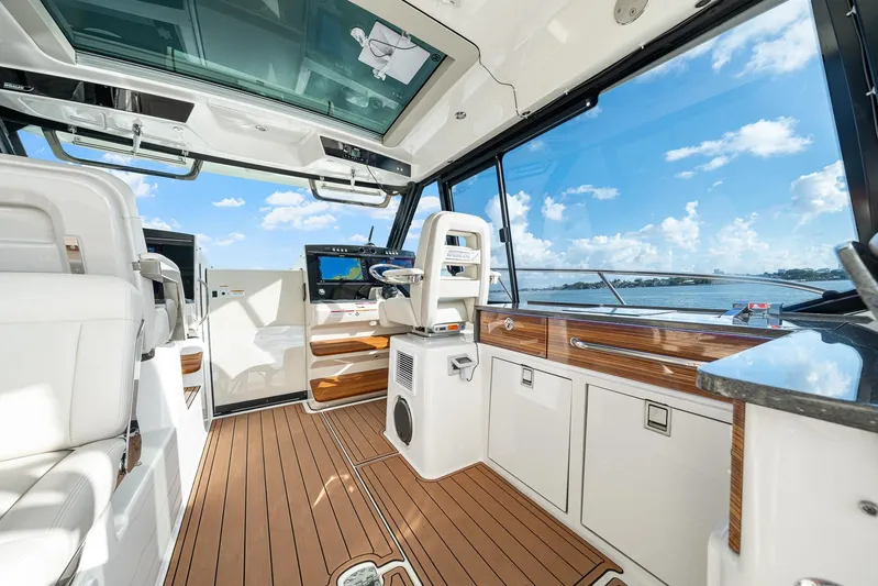  Yacht Photos Pics 2024 Boston Whaler 405 Conquest interior with modern helm, wood accents, and panoramic windows.