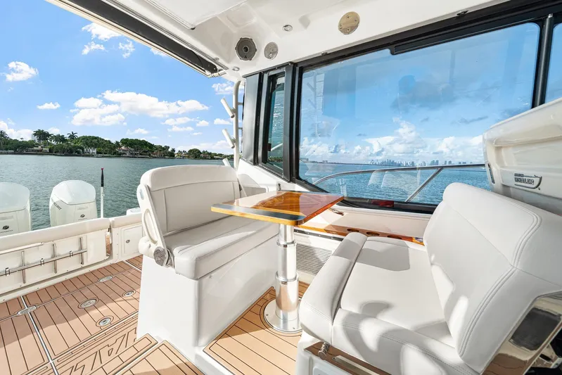  Yacht Photos Pics 2024 Boston Whaler 405 Conquest interior with seating and table, overlooking scenic waterfront.